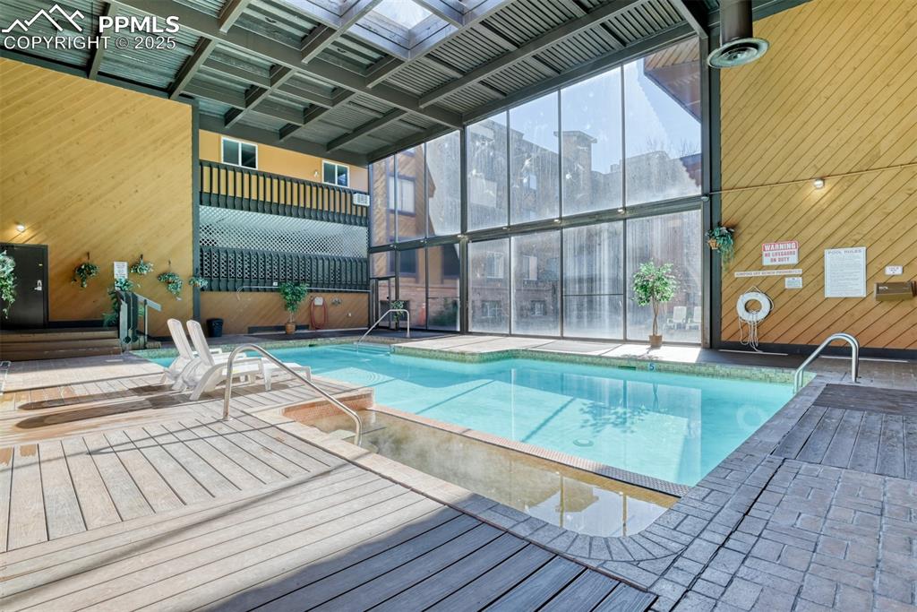 Indoor community pool featuring a deck and a patio