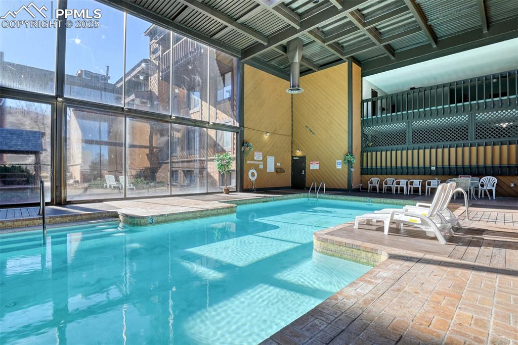 Indoor community pool featuring a patio