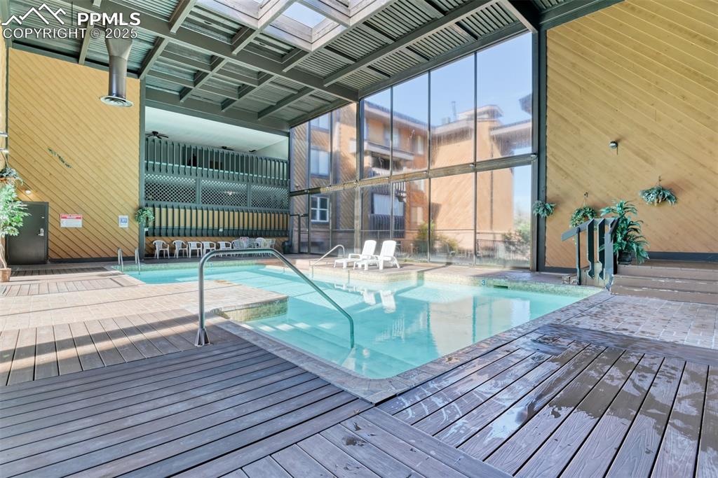Indoor community pool featuring a patio area and a deck