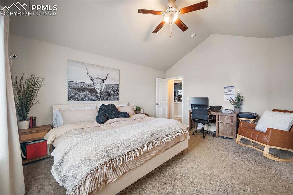 Bedroom featuring carpet flooring, a desk, a ceiling fan, and high vaulted ceiling