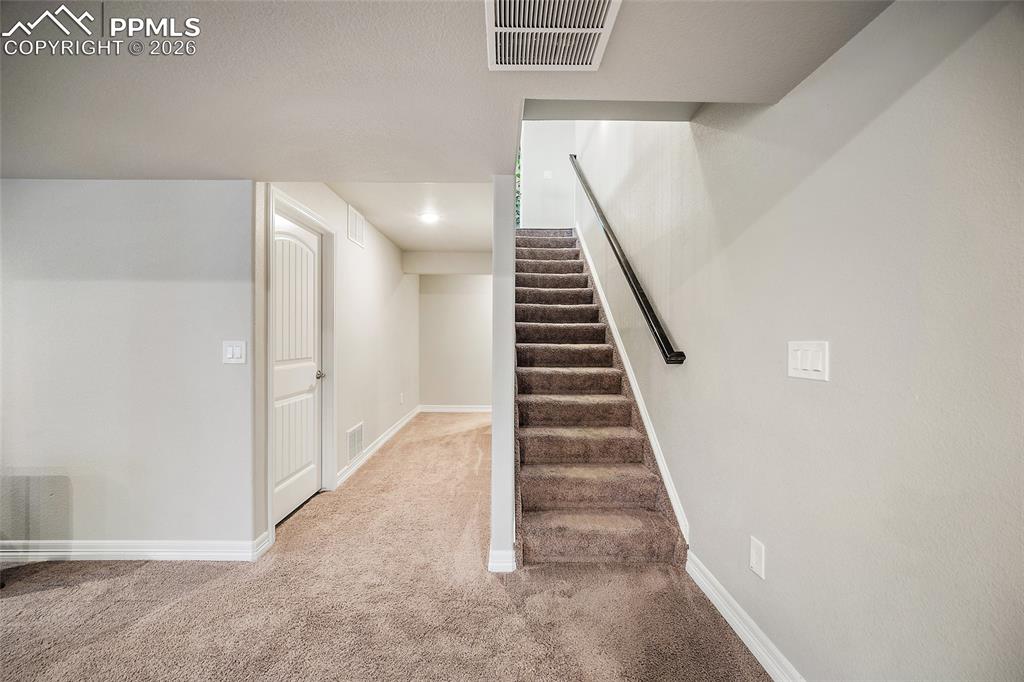 Stairs with baseboards and carpet floors