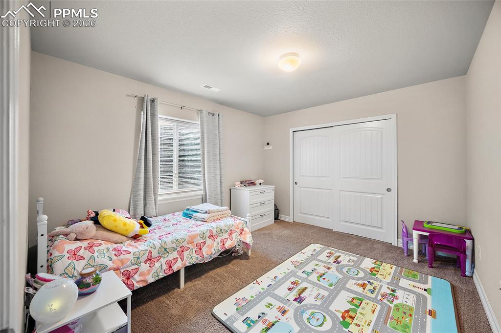 Carpeted bedroom with a closet and baseboards