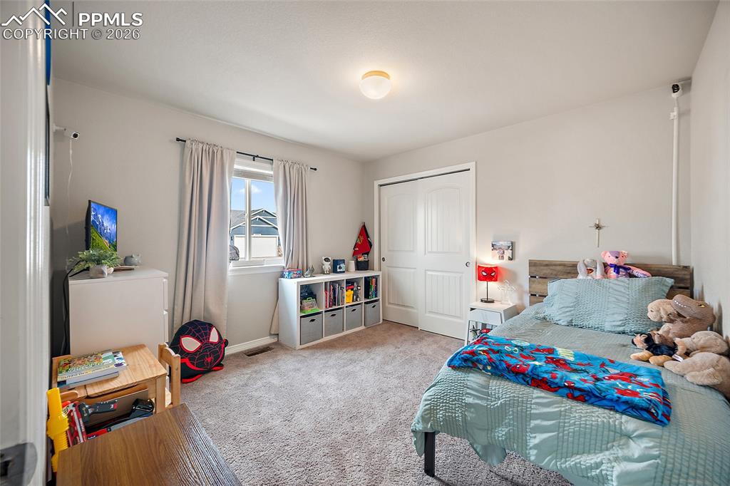 Carpeted bedroom with a closet and baseboards