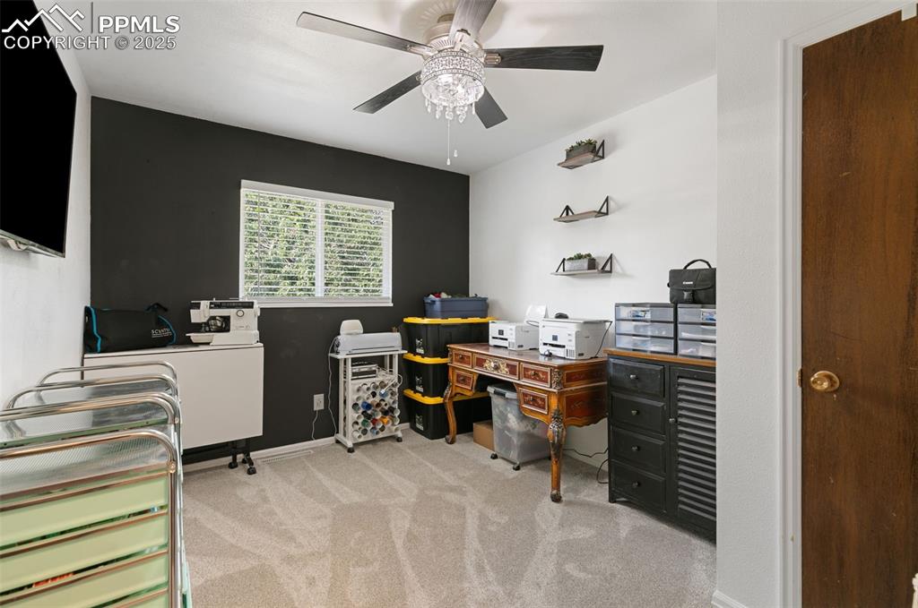 Office area with light carpet and ceiling fan