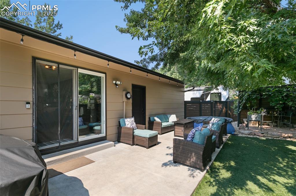 Fenced backyard featuring a patio and an outdoor hangout area