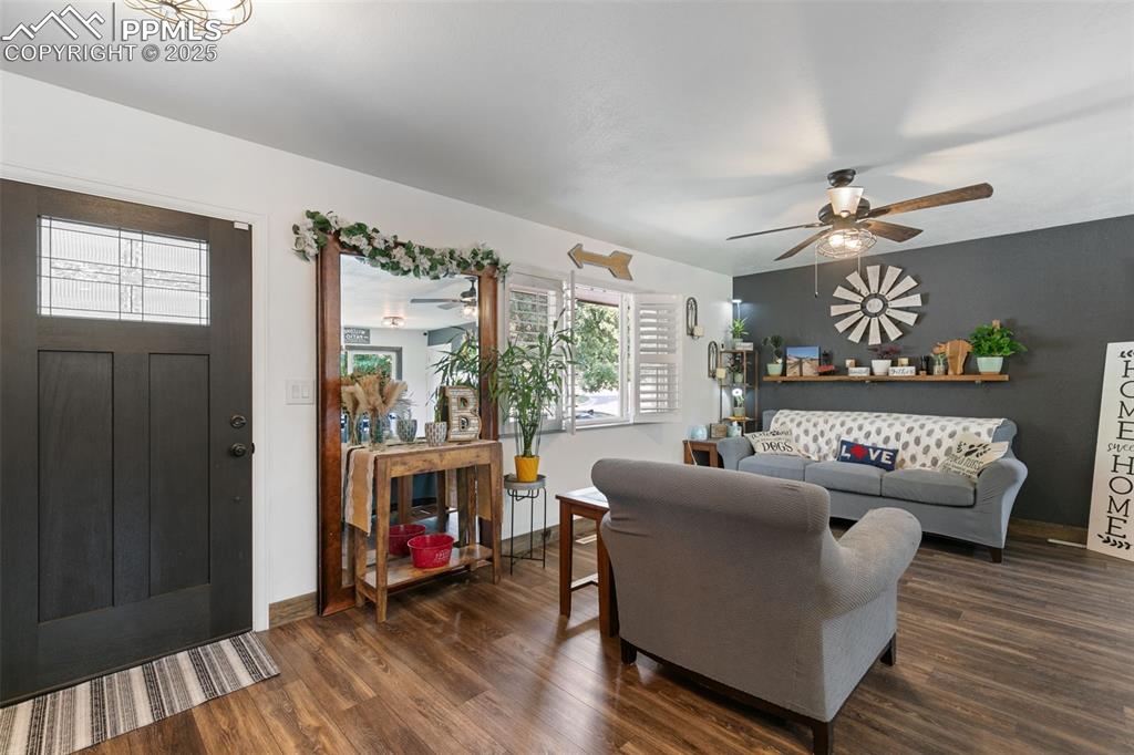 Living room featuring dark wood finished floors and ceiling fan