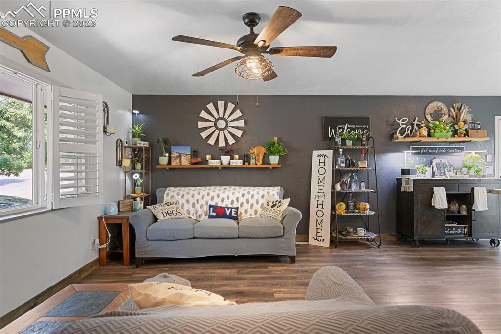 Living area featuring wood finished floors and ceiling fan