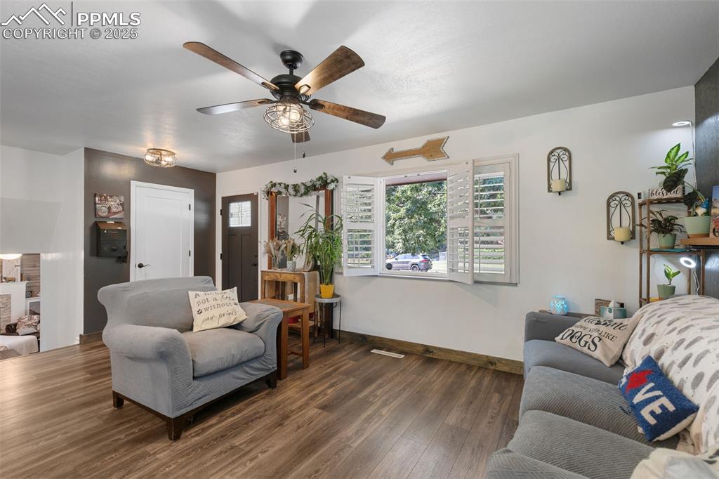 Living area featuring wood finished floors and ceiling fan