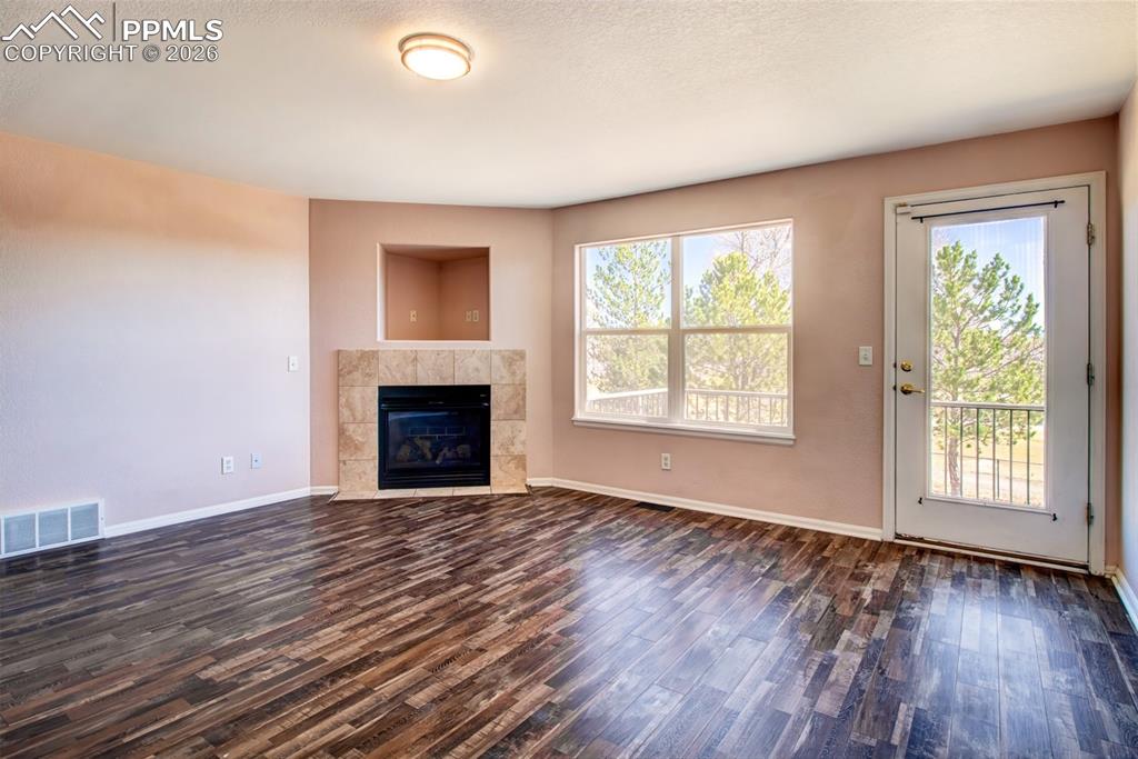 Living room with LVP flooring, a gas fireplace and a walk out to deck
