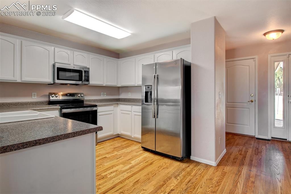Kitchen with wood floors, stainless steel appliances and ample cabinet space