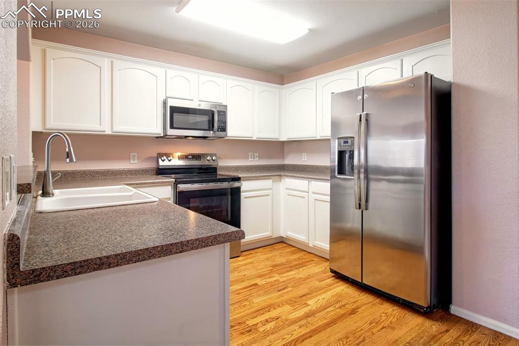 Kitchen with wood floors, stainless steel appliances and ample cabinet space