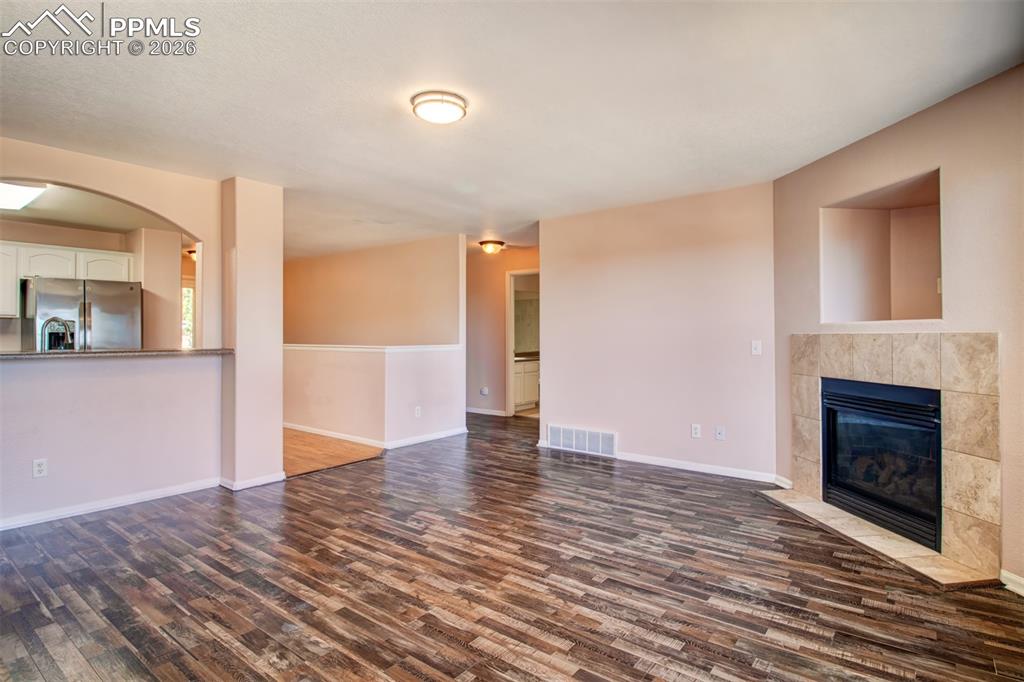 Living room with LVP flooring, a gas fireplace and a walk out to deck