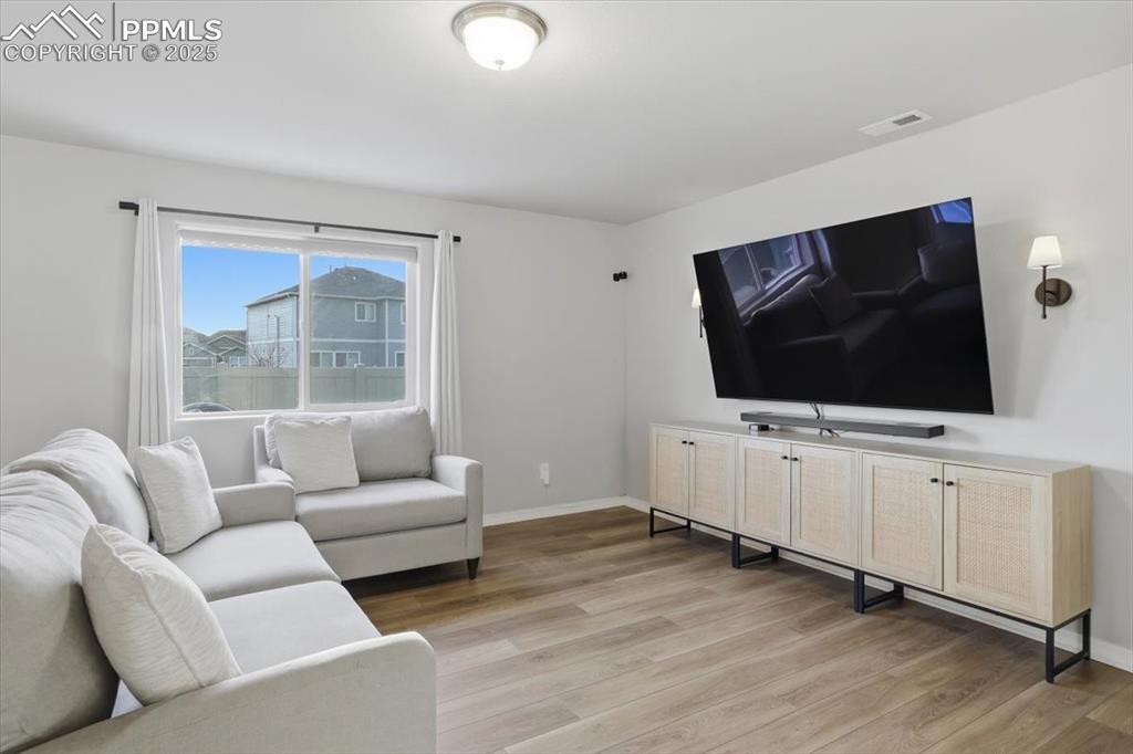 Living room with baseboards and light wood-style flooring