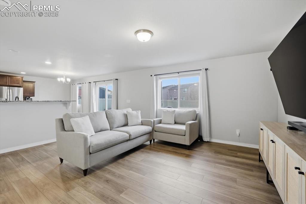 Living room featuring light wood finished floors and a chandelier
