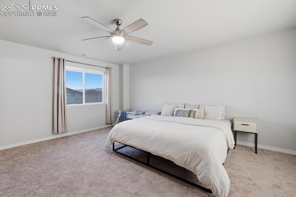 Bedroom featuring light carpet and ceiling fan