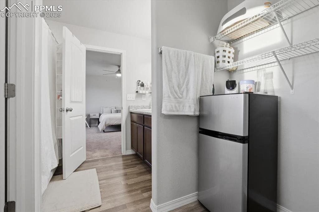 Bathroom with vanity, a shower with curtain, ensuite bathroom, ceiling fan, and light wood-type flooring