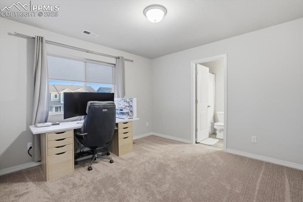 Home office featuring light colored carpet and baseboards
