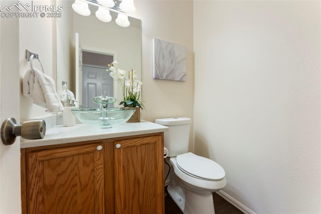 Half bathroom with vanity and toilet