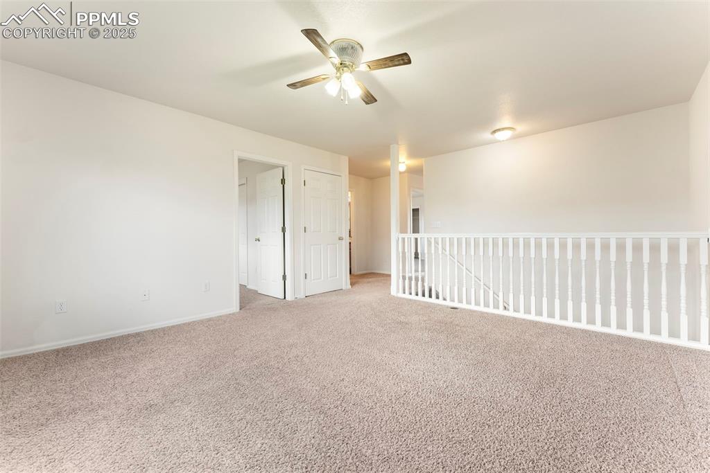 Carpeted empty room with baseboards and ceiling fan
