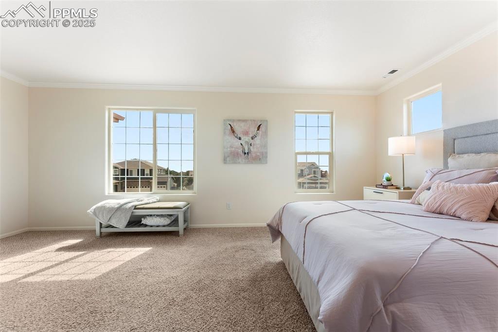 Bedroom featuring crown molding and carpet