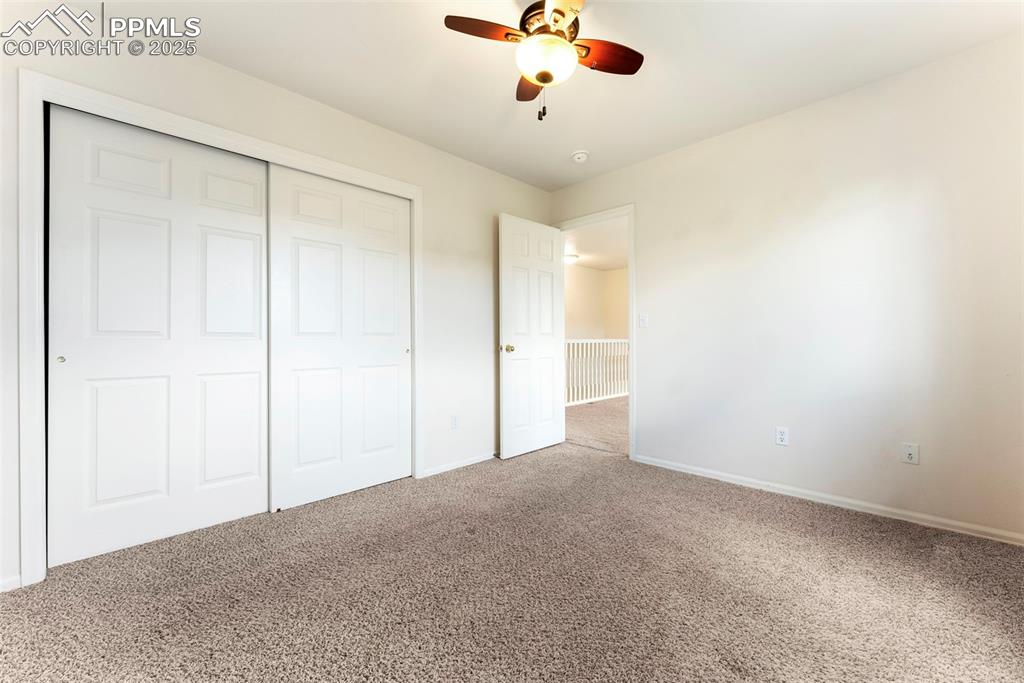 Unfurnished bedroom featuring carpet flooring, a closet, and ceiling fan