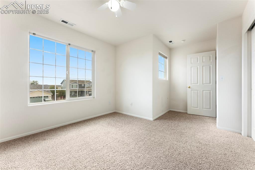 Unfurnished bedroom featuring light carpet and ceiling fan