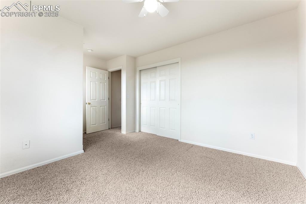 Unfurnished bedroom featuring carpet, a closet, and ceiling fan