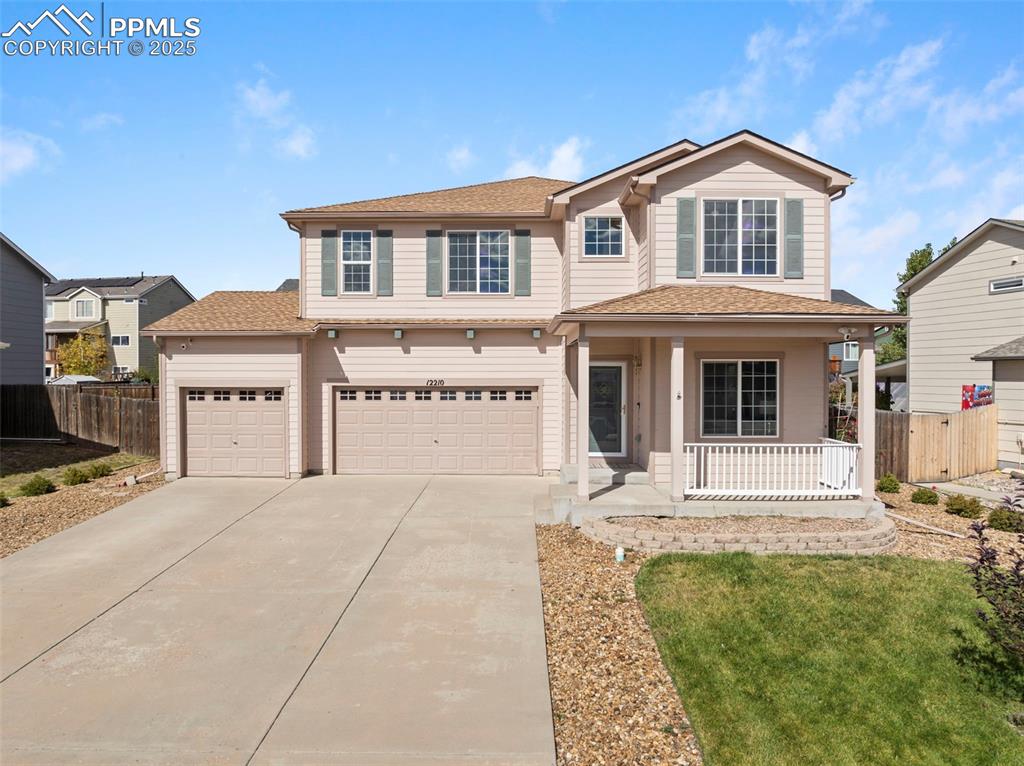 Traditional-style home with a porch, concrete driveway, and a shingled roof
