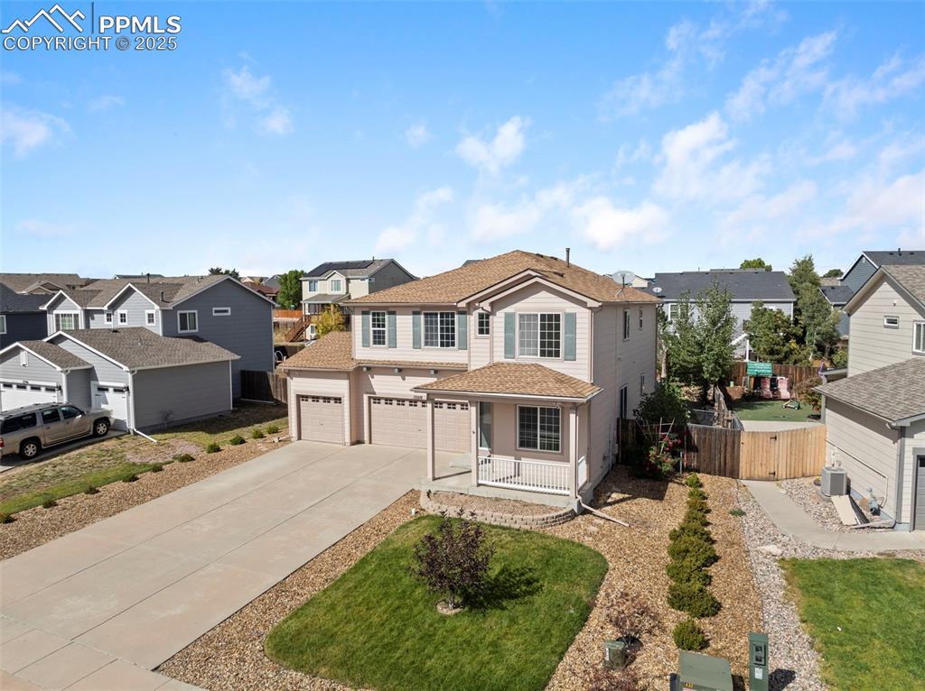 Traditional home featuring a residential view, a garage, and concrete driveway