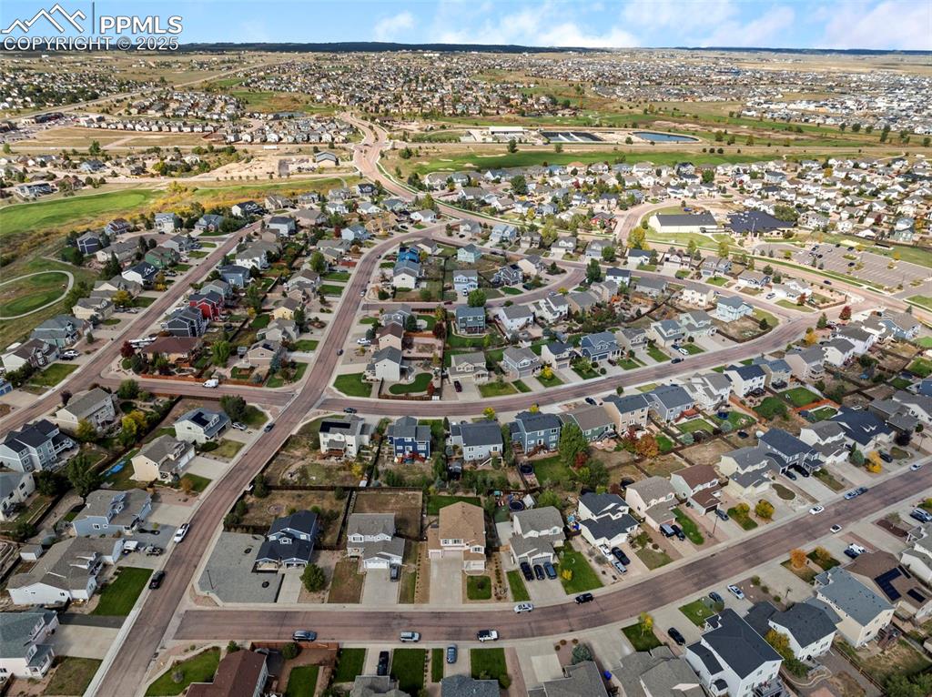 Aerial view of property and surrounding area featuring nearby suburban area