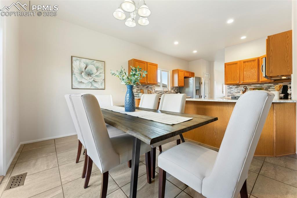 Dining space with a chandelier, recessed lighting, and light tile patterned floors