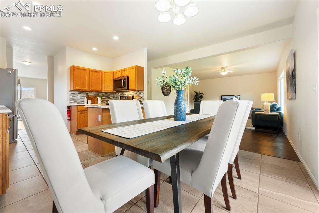 Dining room featuring light tile patterned flooring, recessed lighting, and a chandelier