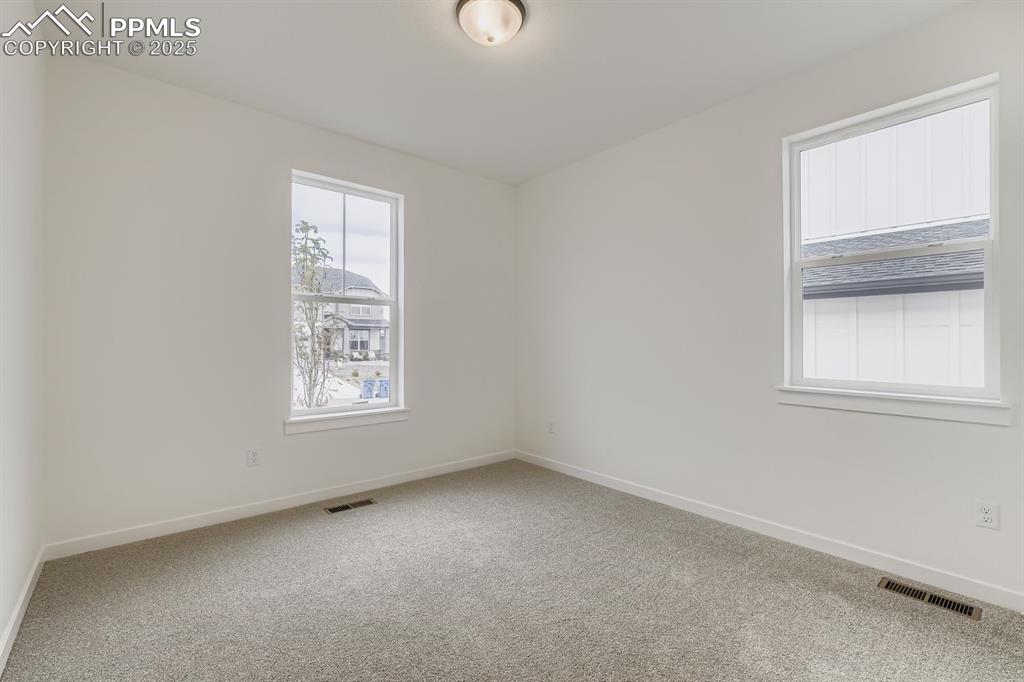Empty room featuring light colored carpet and healthy amount of natural light