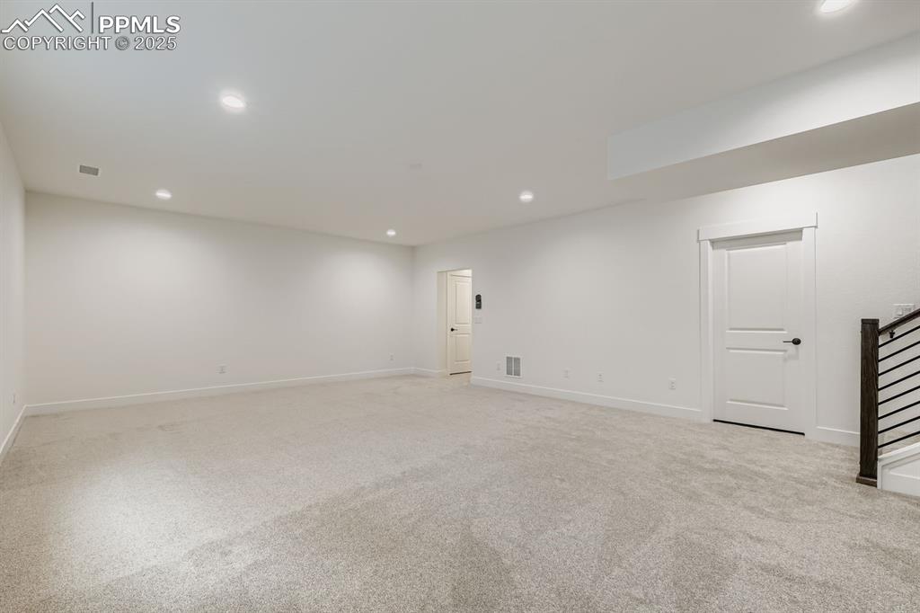 Below grade area with recessed lighting, light carpet, and stairway