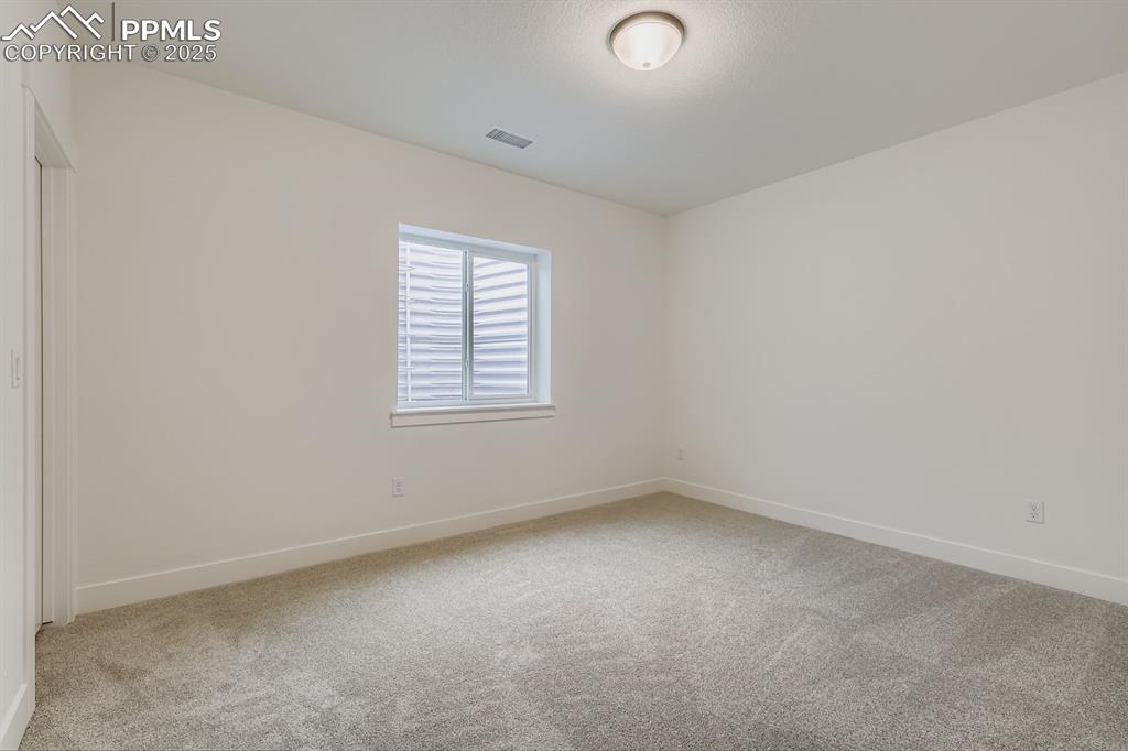 Spare room featuring light carpet and baseboards