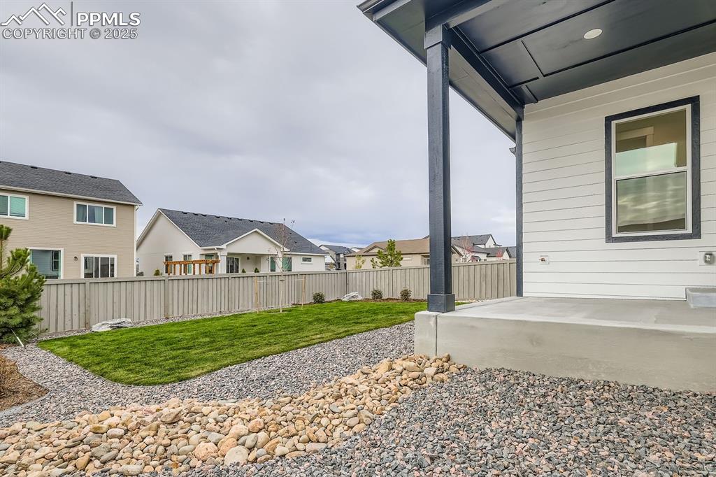 Fenced backyard featuring a residential view and a patio