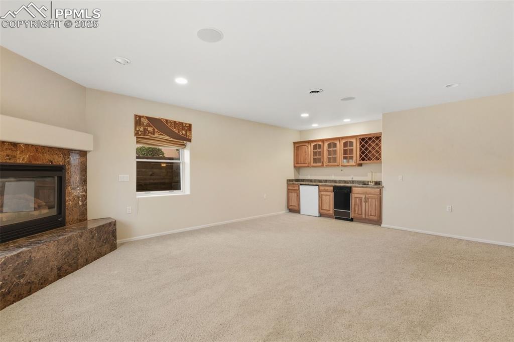 Downstairs Family Room 2 of 2 with fireplace and wet bar kitchenette