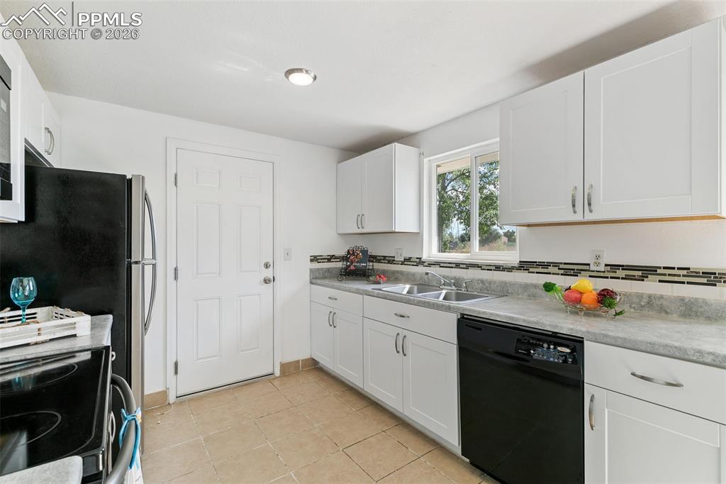 Kitchen with dishwasher, white cabinets, light countertops, range with electric stovetop, and light tile patterned flooring