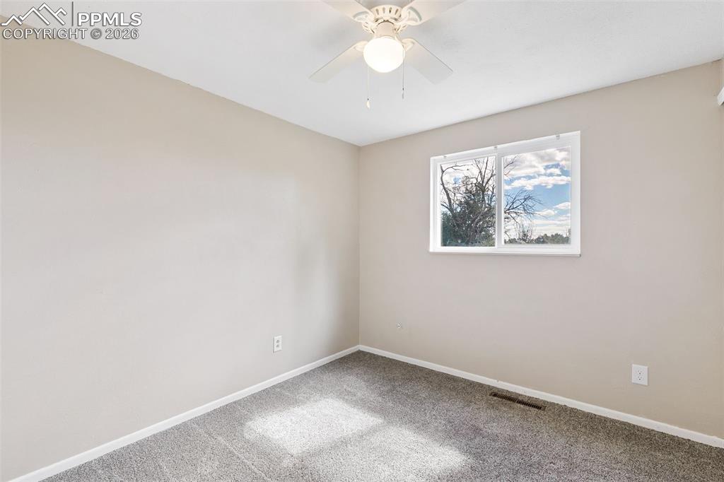 Spare room featuring carpet flooring and ceiling fan