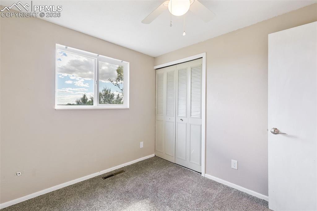 Unfurnished bedroom with a closet, ceiling fan, and carpet