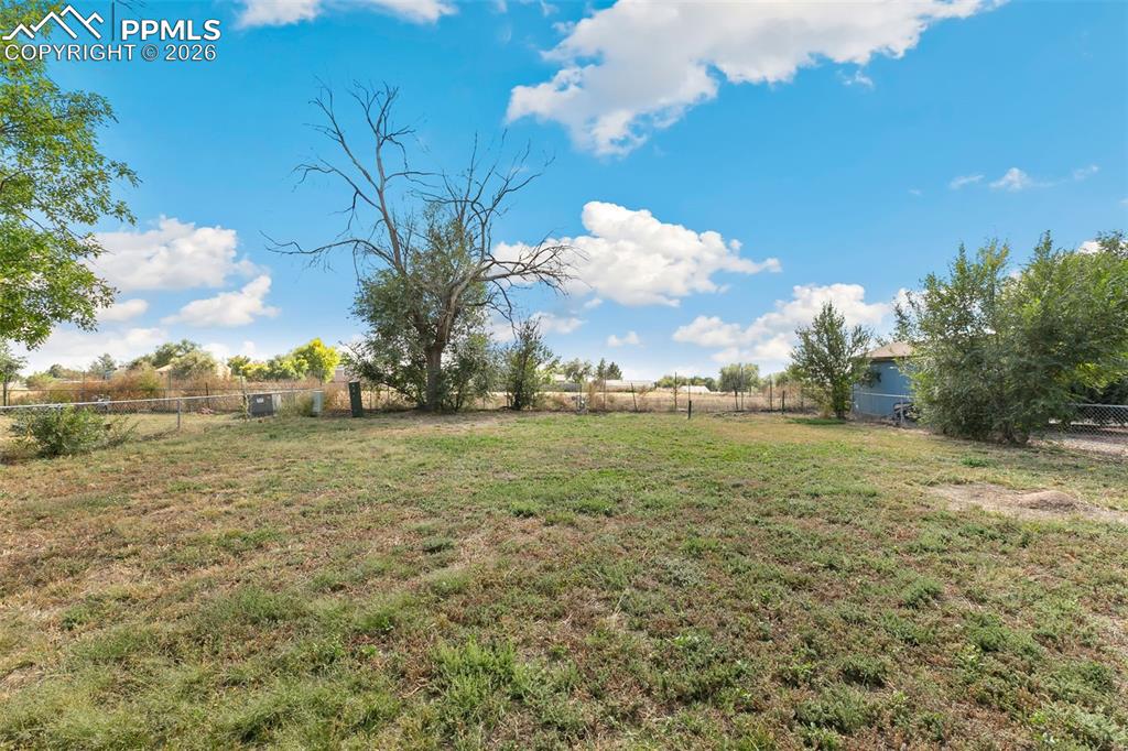 Fenced backyard featuring a view of countryside