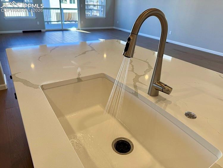 Kitchen with Quartz countertops, pantry, large island providing additional seating, stainless steel gas range, pyramid hood, microwave drawer, and dishwasher! 