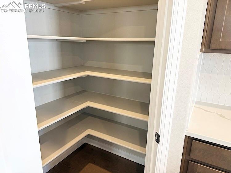 Kitchen with Quartz countertops, pantry, large island providing additional seating, stainless steel gas range, pyramid hood, microwave drawer, and dishwasher!