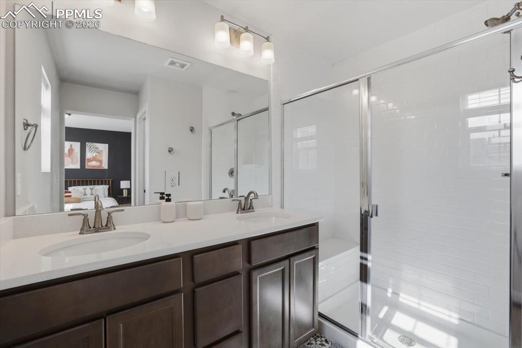 Primary bathroom with dual sinks and walk-in shower.