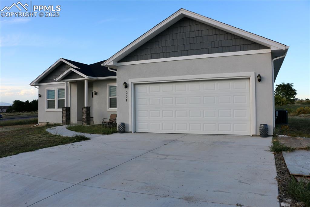 Single story home featuring stucco siding, concrete driveway, and an attached garage