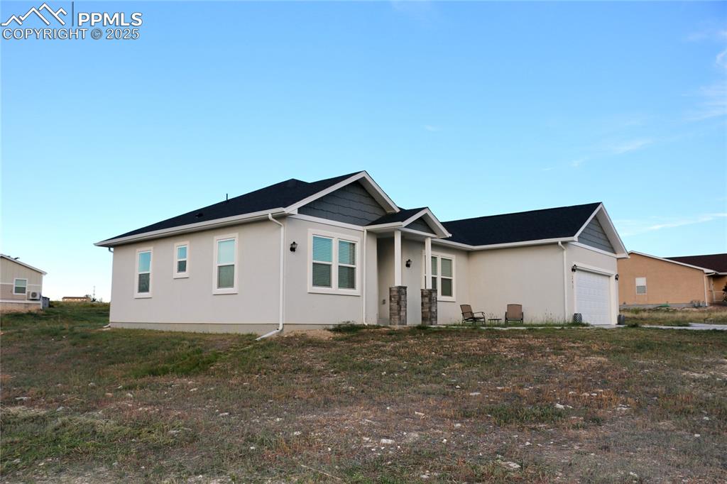 View of front of home featuring an attached garage and stucco siding