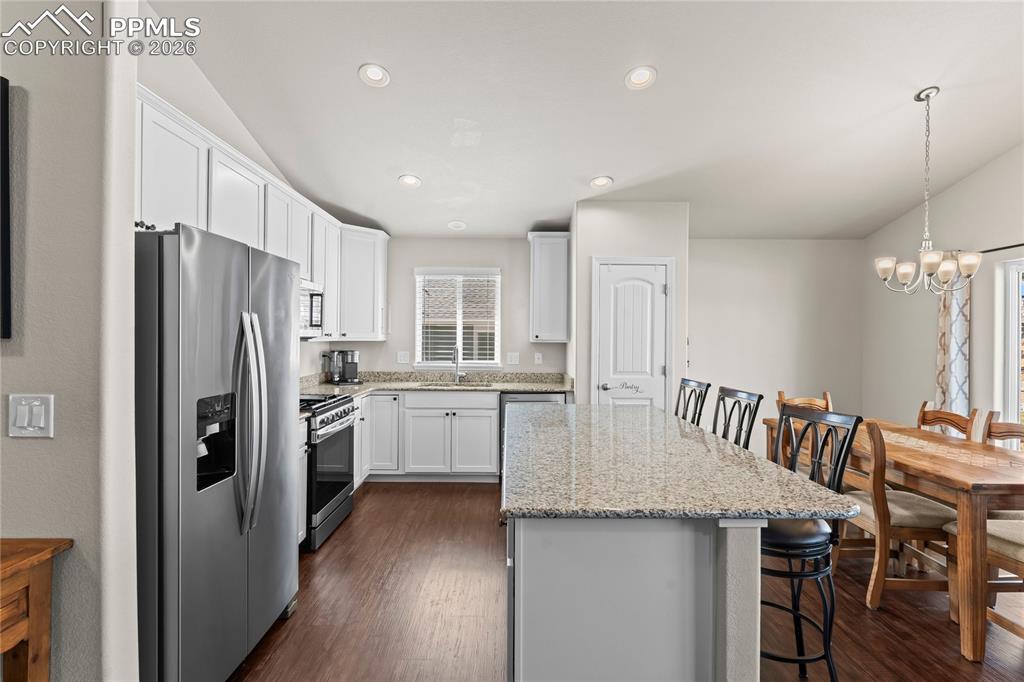 Take a close look at this beautiful kitchen with a large island, stainless appliances, granite countertops, lots of cabinets and a pantry!