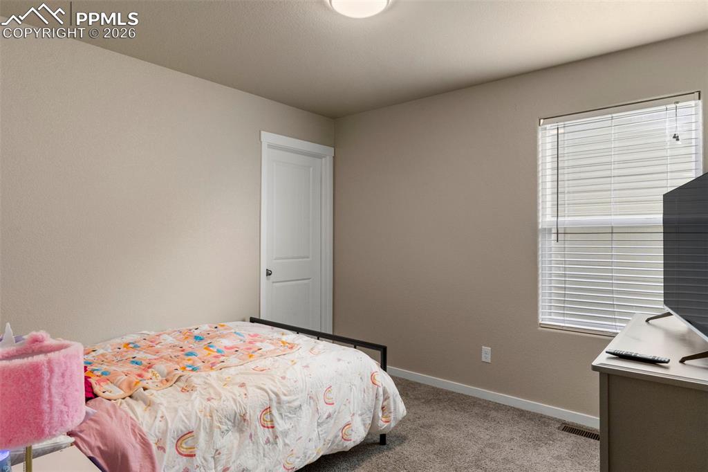 Bedroom with light colored carpet and baseboards