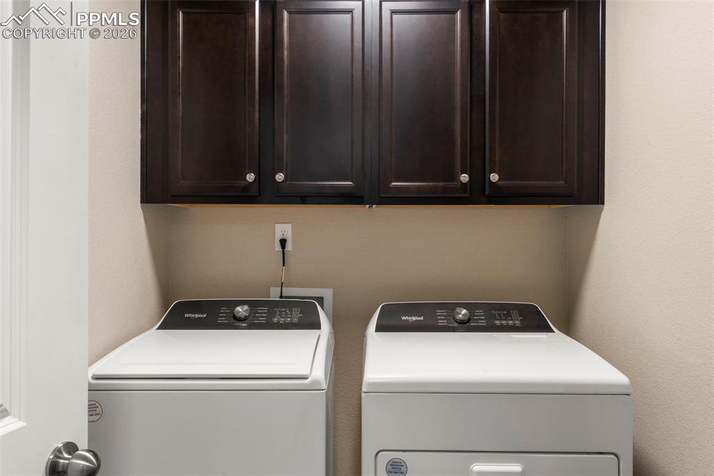 Laundry room with separate washer and dryer and cabinet space