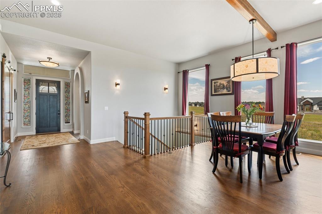 Dining room featuring dark wood finished floors and beamed ceiling